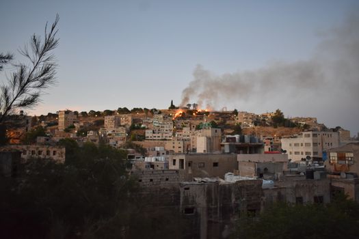 A Burning Field in a Hill Near Buildings