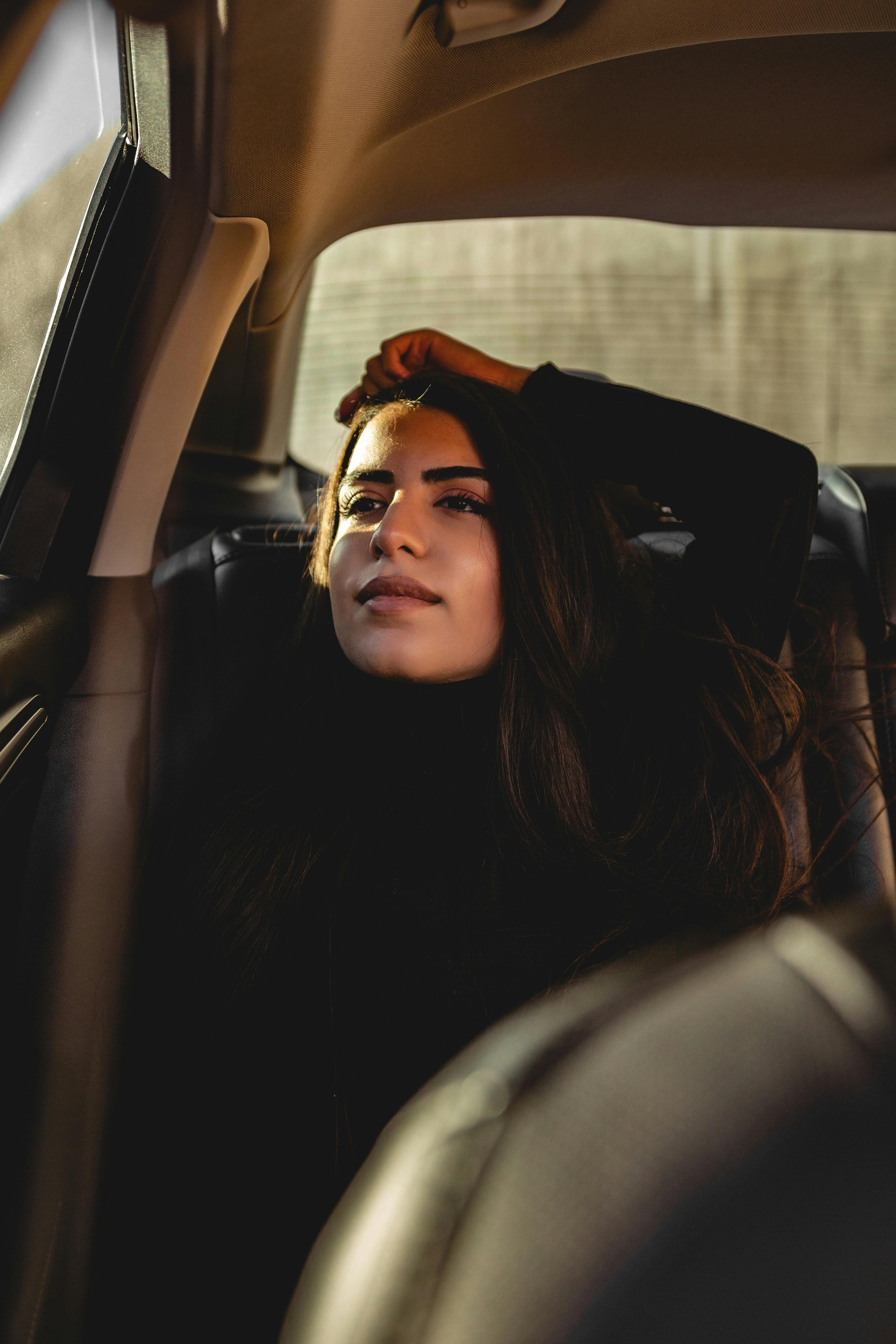 Woman in Black Leather Jacket Sitting on Car Seat · Free Stock Photo