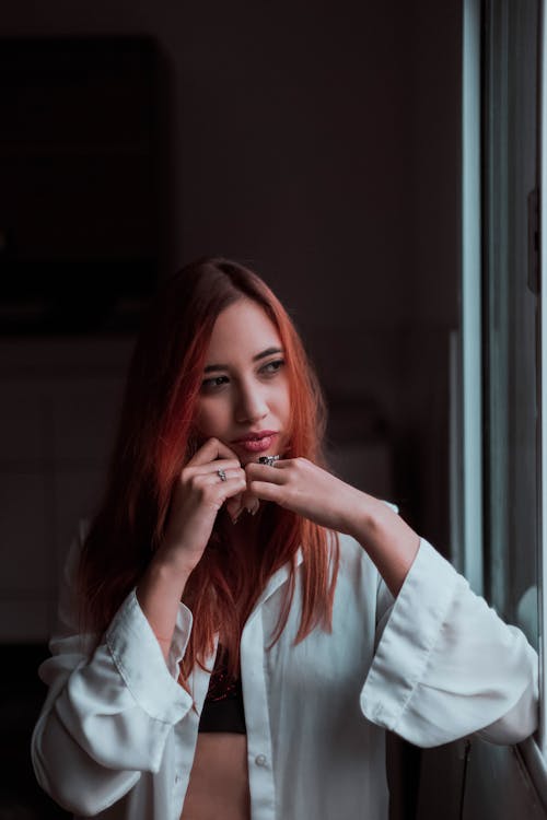 Thoughtful millennial girl standing in dark room