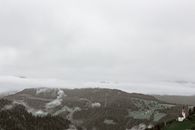 薄雾笼罩的山区，景色宁静，一座古色古香的教堂坐落在绿色的森林中