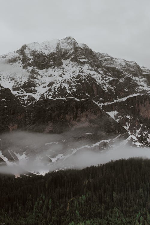 Clouds over endless forest near mountain ridge