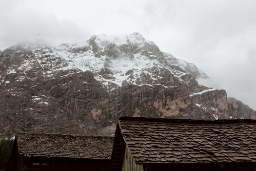 冬日里，白雪覆盖着山峰和乡村屋顶，天空多云