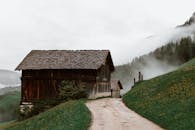 沿着薄雾笼罩的山路，有一间乡村小屋，映衬着宁静的乡村风光