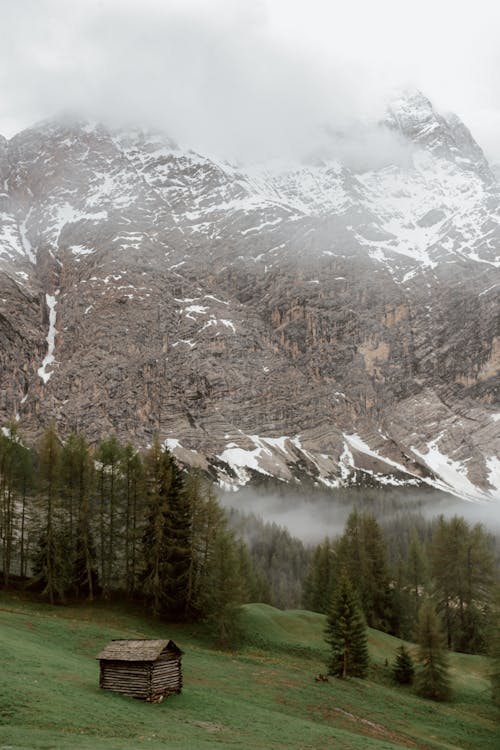 Fog above wooden house in mountain valley