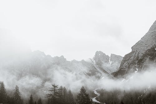 Snowy mountain peaks under thick fog and clouds