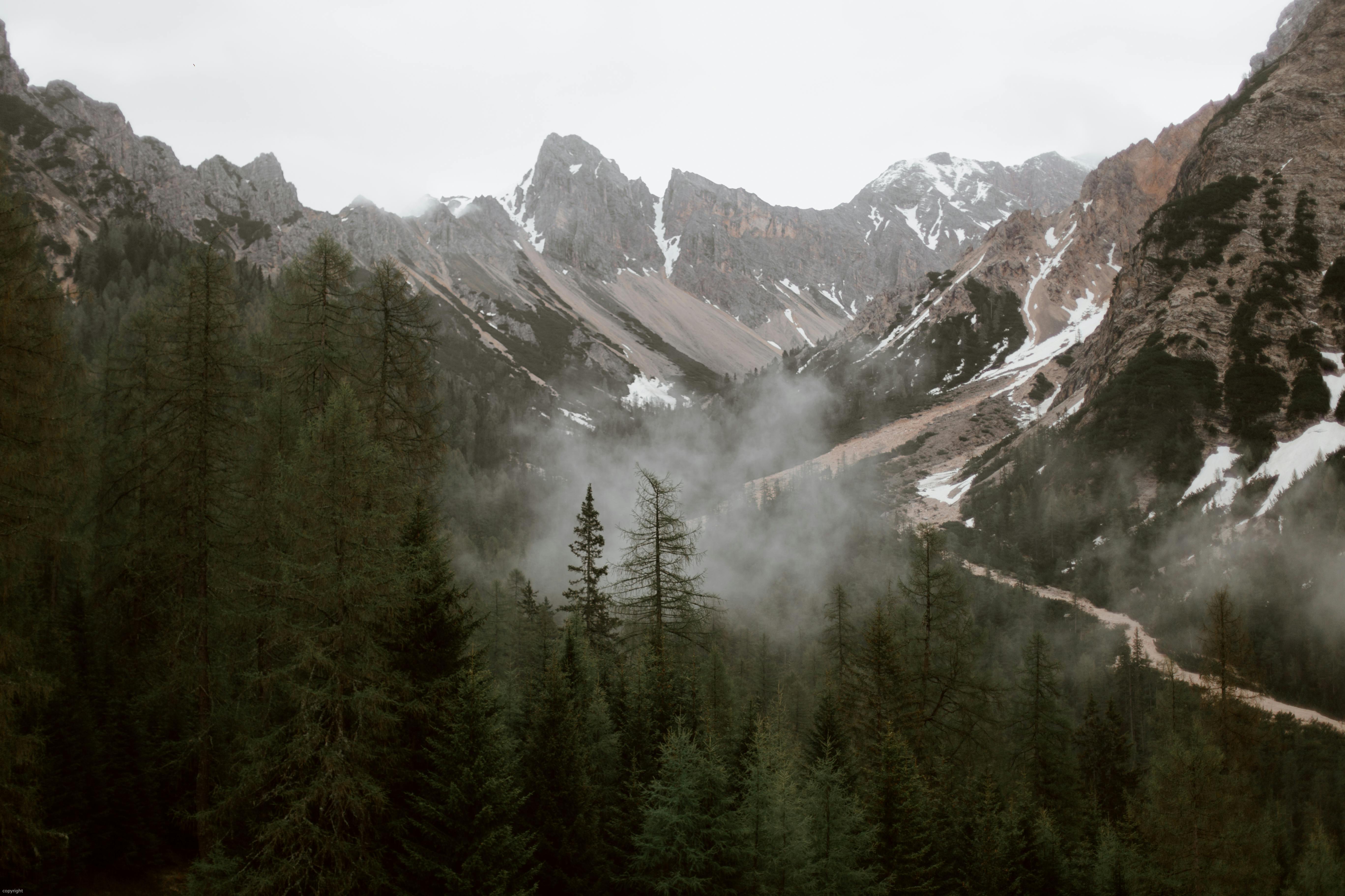 Mountain ridge with snowy peaks under gray sky