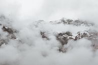 浓雾笼罩着大片山脉和白雪皑皑的岩石斜坡，天色阴沉