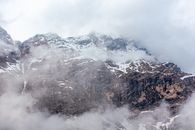 云层笼罩着山峰，景色令人惊叹，展现了大自然的壮丽