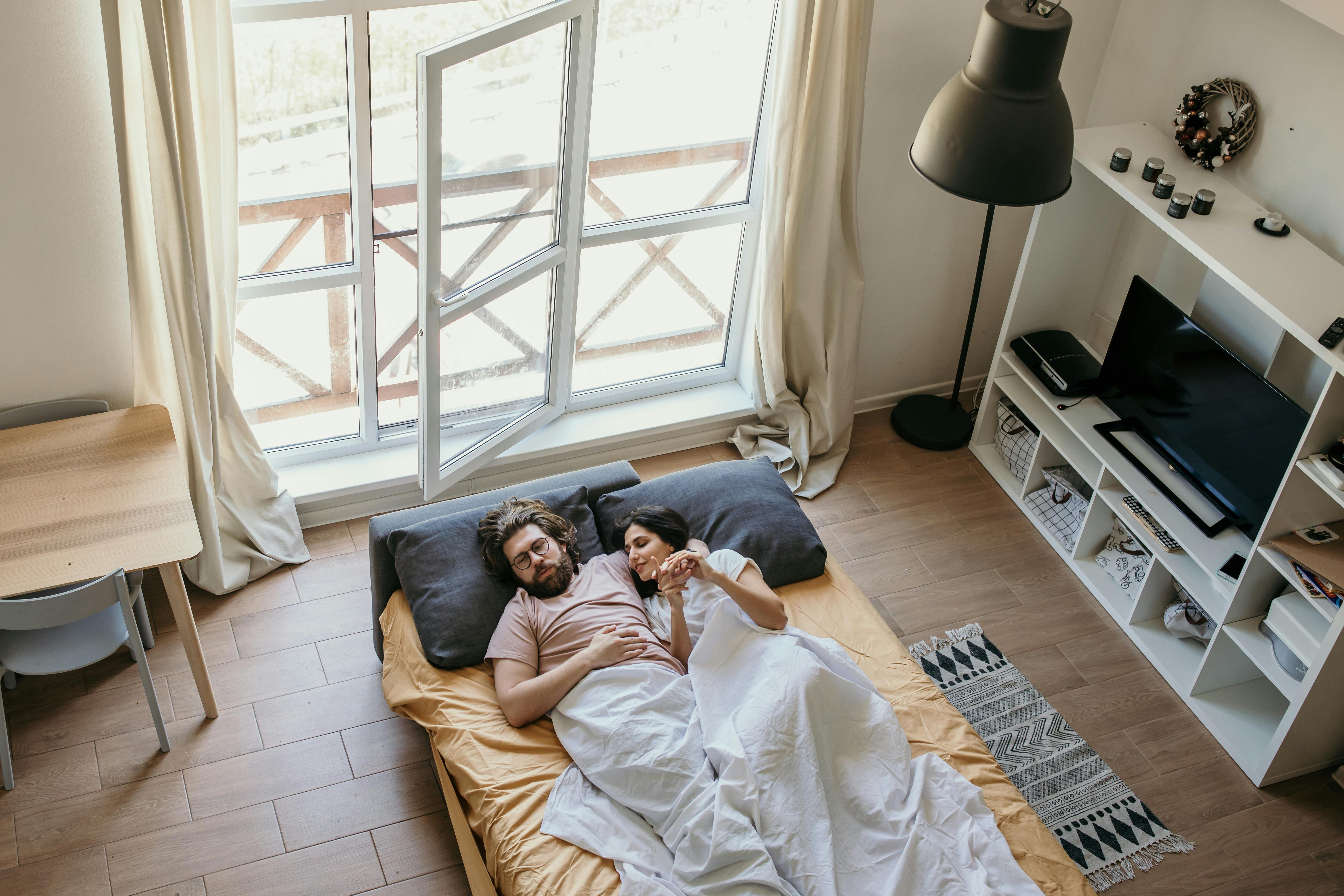 Man and woman lying on bed. | Photo: Pexels