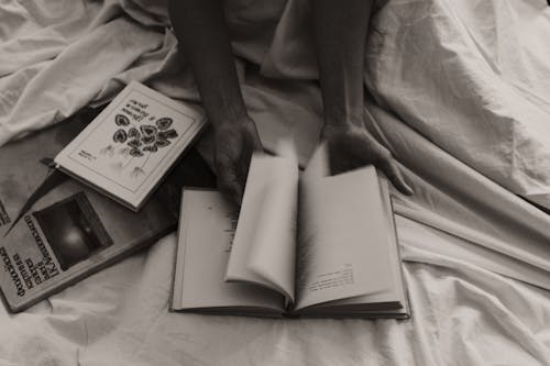 Grayscale Photo Of Hands Flipping Book Pages