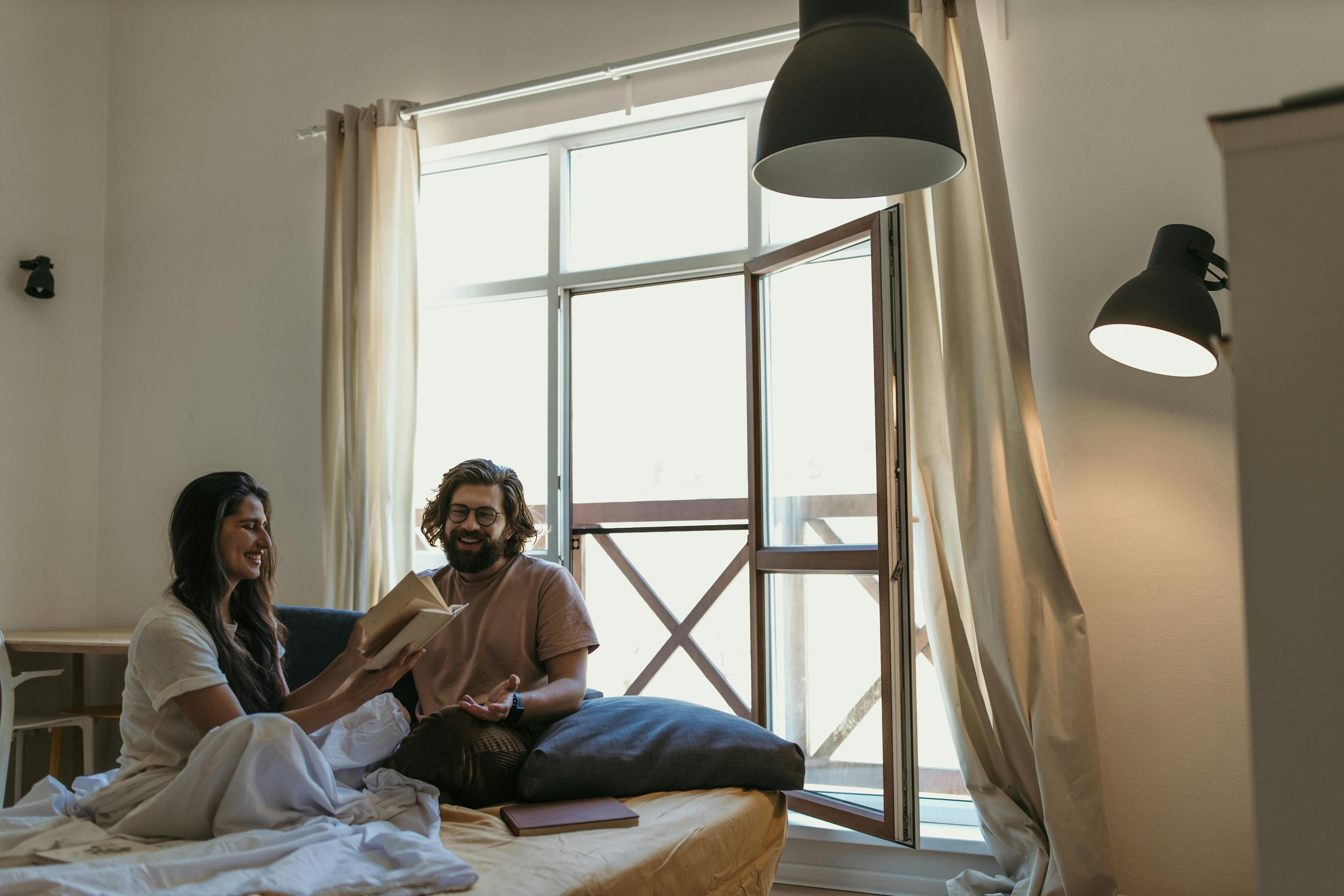 Woman and man sitting on bed. | Photo: Pexels