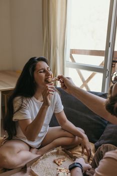 一对夫妇在室内轻松地分享美味的披萨