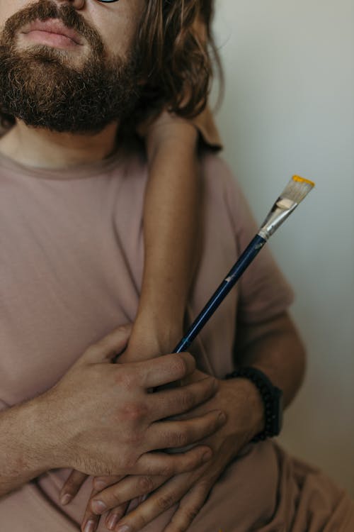 Man in Gray Tank Top Holding Black Pen