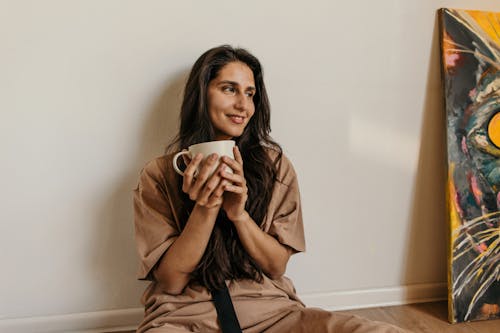 Free Woman in Brown Coat Holding White Ceramic Mug Stock Photo