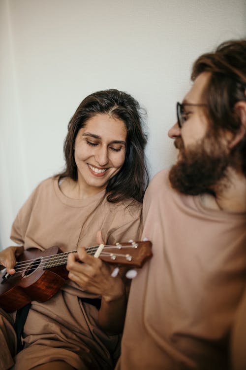 Woman in Brown Crew Neck Shirt Holding Brown Acoustic Guitar
