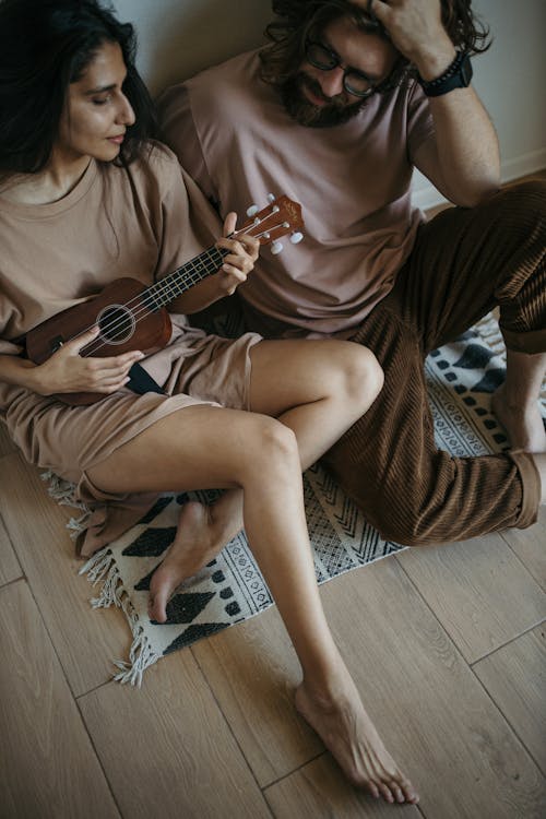 Woman in Brown Long Sleeve Shirt Playing Brown Acoustic Guitar
