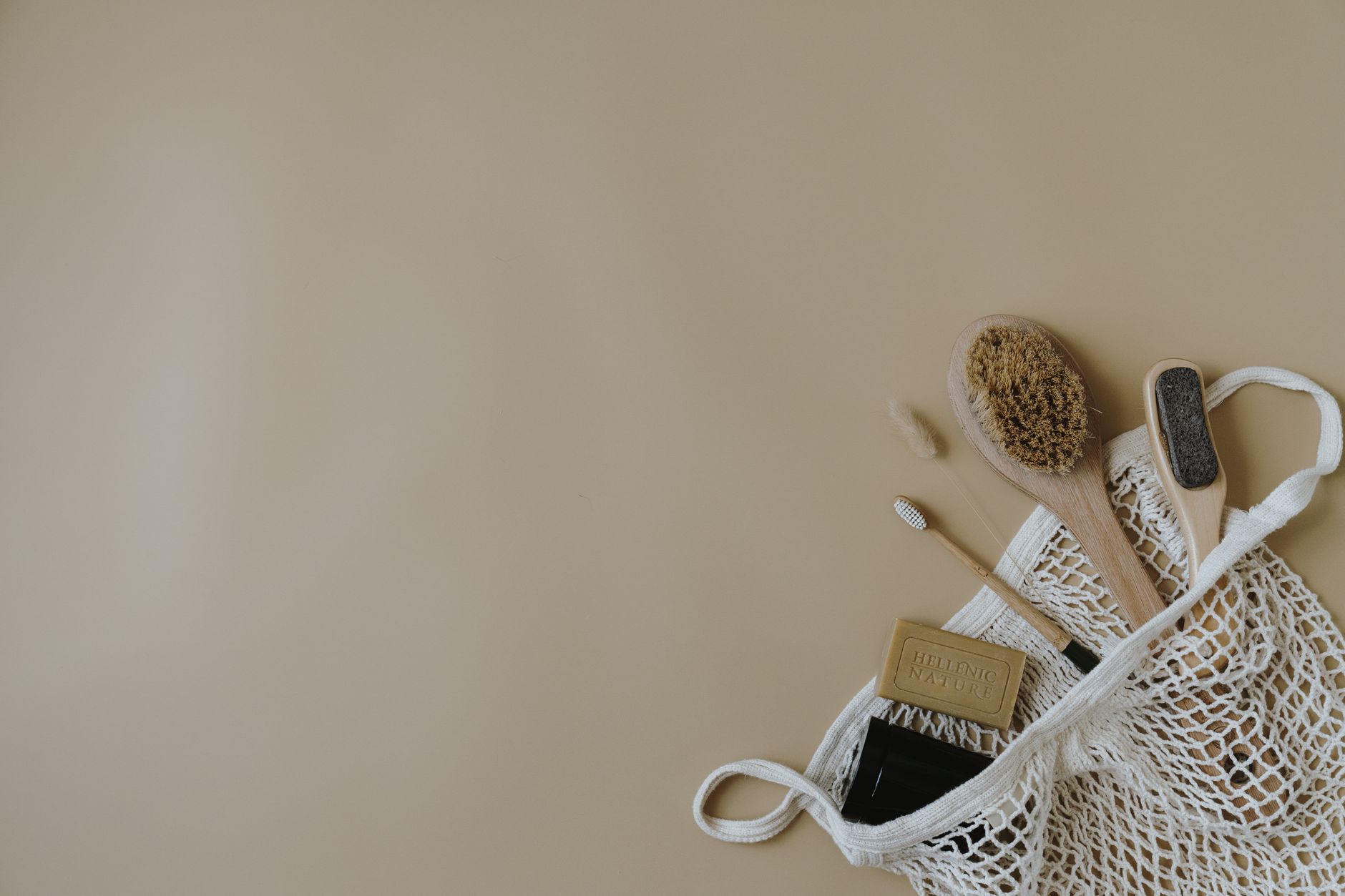 Collection of eco-friendly bath essentials, featuring a wooden brush and soap in a mesh bag. Ideal for zero waste lifestyle.