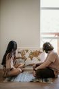 Woman in White Shirt Sitting Beside Woman in Brown Shirt
