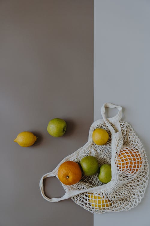 Citrus Fruits and Green Apples on a White Mesh Bag