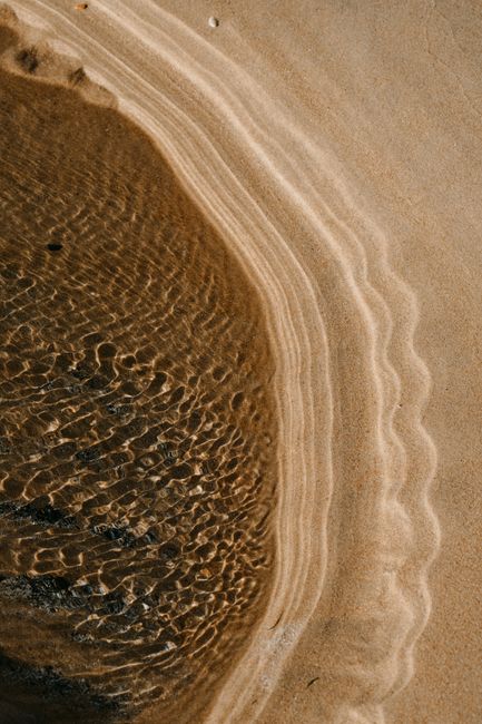 Intricate sand patterns on a beach in Scotland, showcasing natural artistry.
