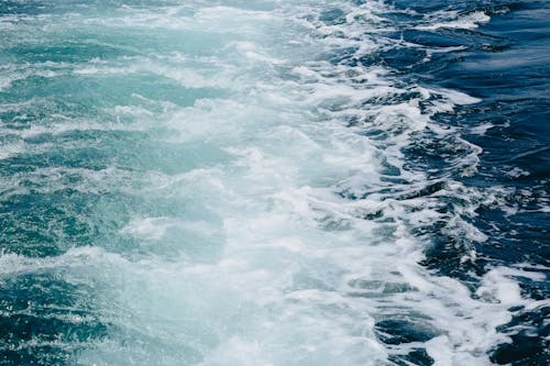 Waves behind cruise ship sailing on sea