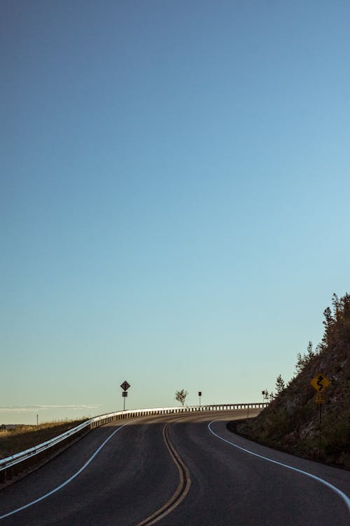 Gratis lagerfoto af asfaltvej, blå himmel, buet