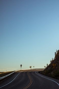 A peaceful curved road under a clear blue sky in Colorado's serene landscape.