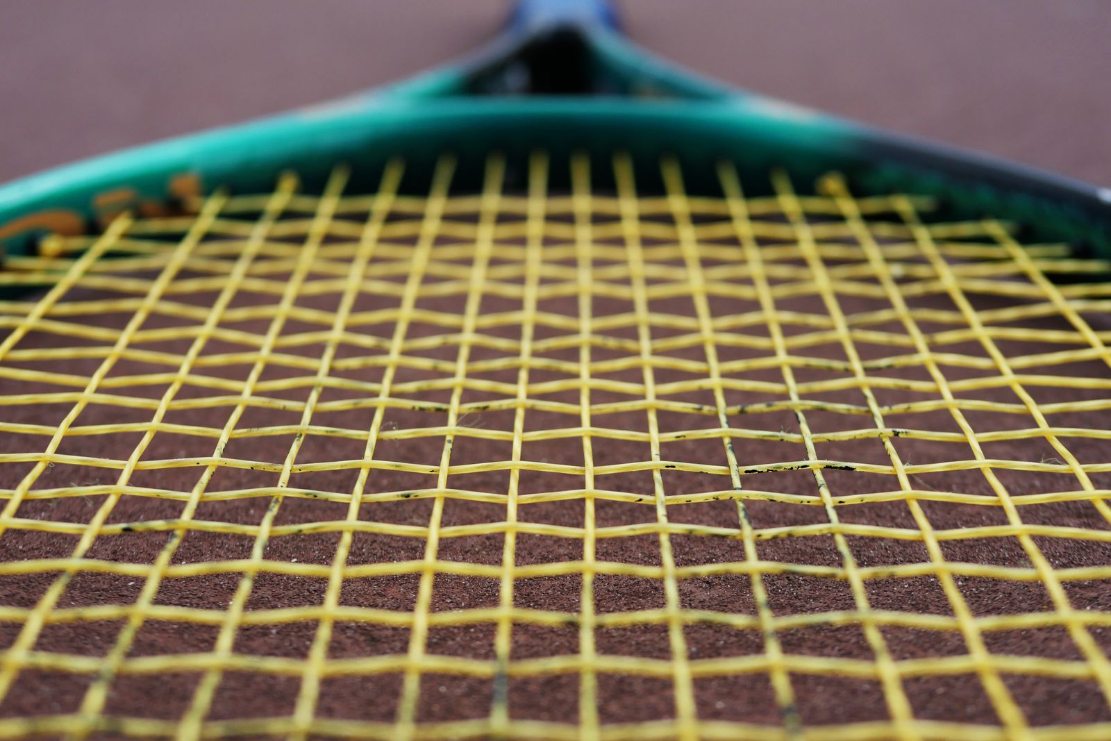 A yellow tennis racket strings in macro photography