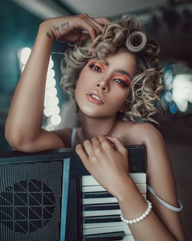 一位自信的年轻女歌手，化着妆，顶着一头卷发，在音乐会前站在现代录音室里，手里拿着合成器