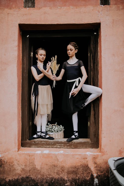 Young girls standing on windowsill