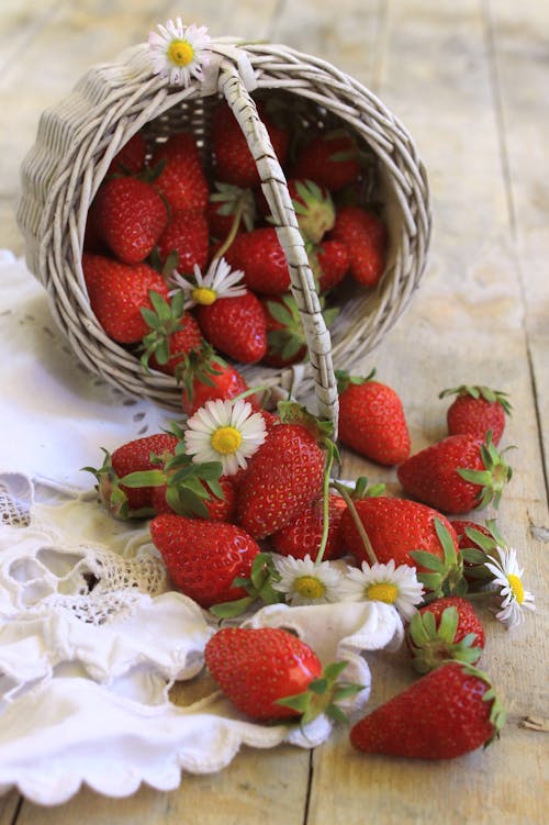A Bunch of Red Strawberries in Woven Basket and  Wooden Surface