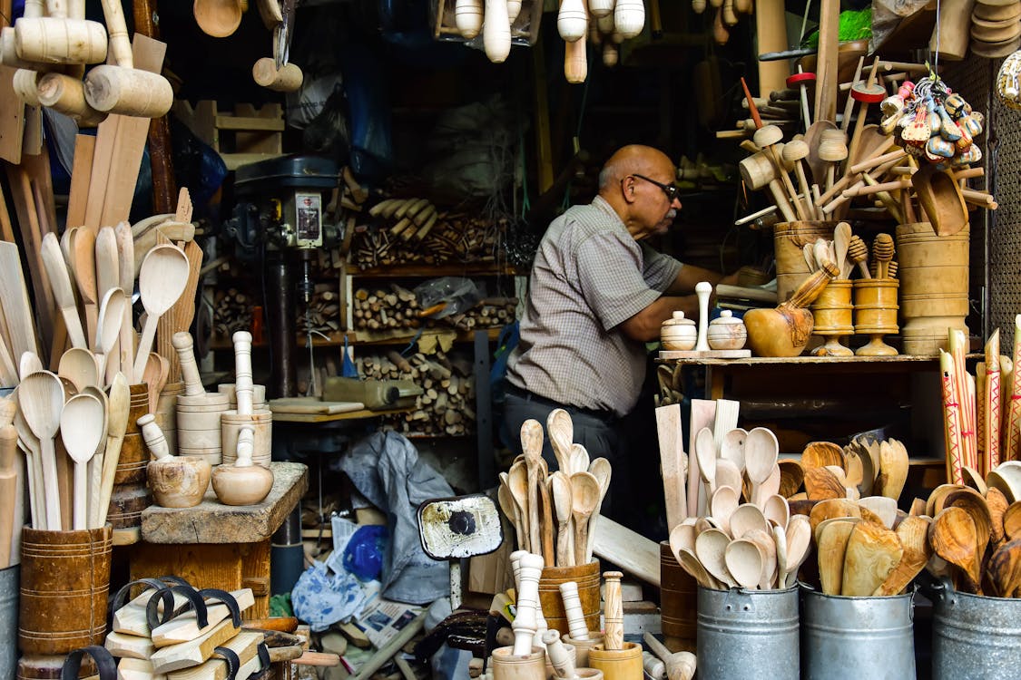 Free A Man in a Store of Wooden Assorted Items Stock Photo