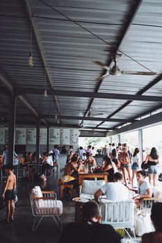 Group of anonymous people resting and having lunch in modern resort cafe during holidays