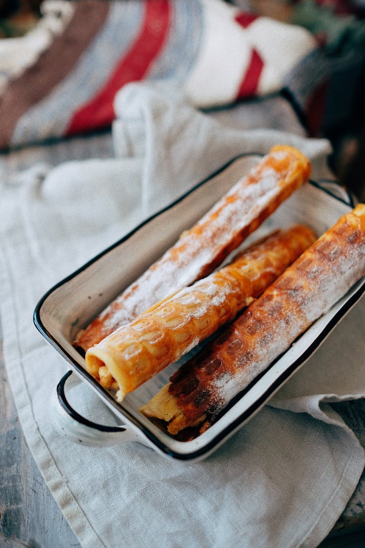 Delicious Sweet Rolled Wafers In Baking Dish Placed On Kitchen Towel