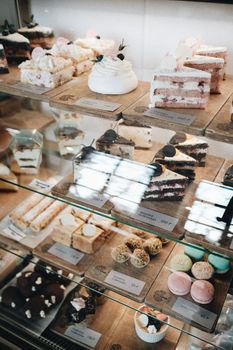 From above of glass showcase with assorted delicious sweet cakes and pastries in bakery shop