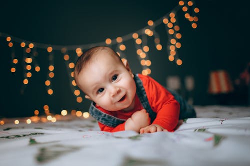 Happy little boy crawling on sheet