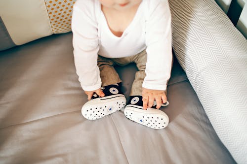Free Little baby in cool shoes on bed Stock Photo
