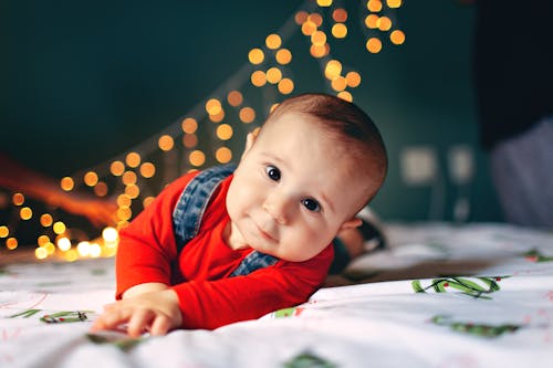 Free Adorable baby lying on soft bed Stock Photo