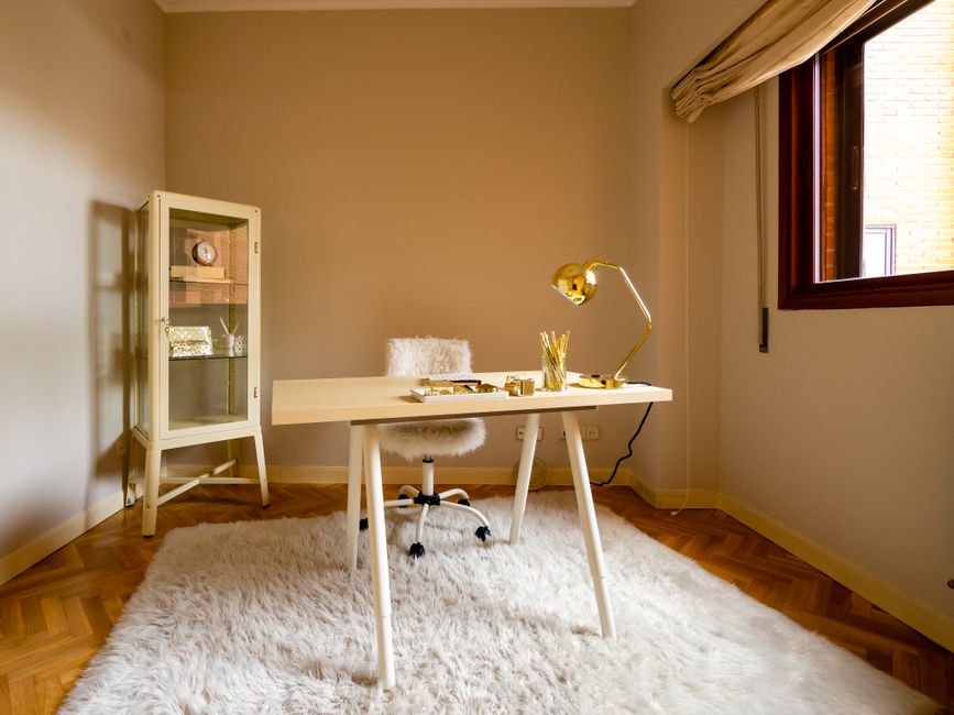 Home Office mit großem Teppich, Bücherregal und schweren Vorhängen für bessere Akustik