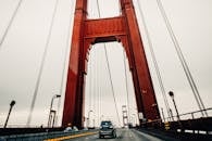 Cars riding along asphalt surface of famous Golden Gate Bridge in San Francisco on cloudy overcast day