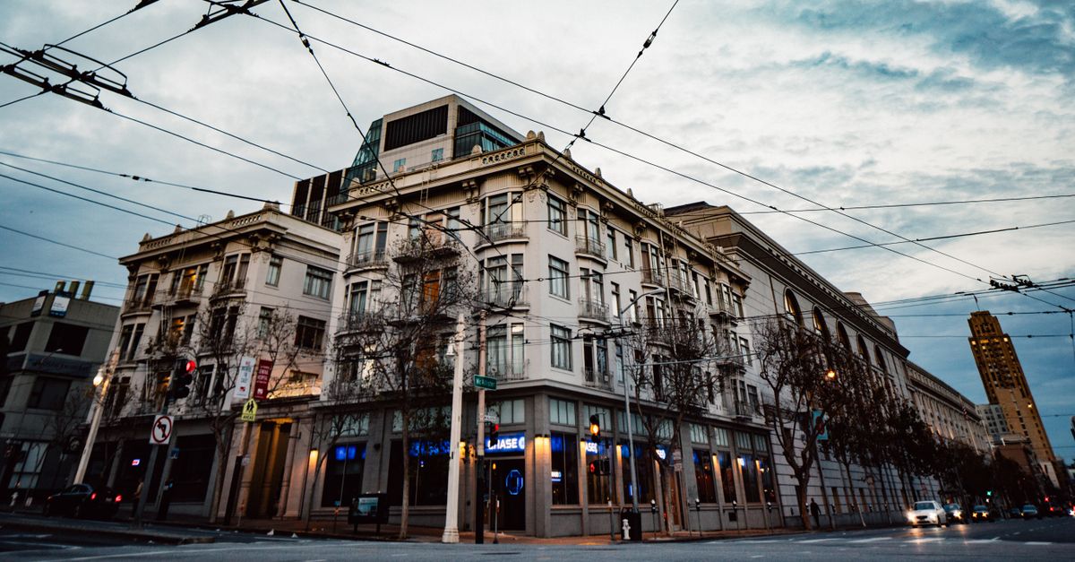 Exterior of contemporary apartment buildings located on crossroad against cloudy sky in evening
