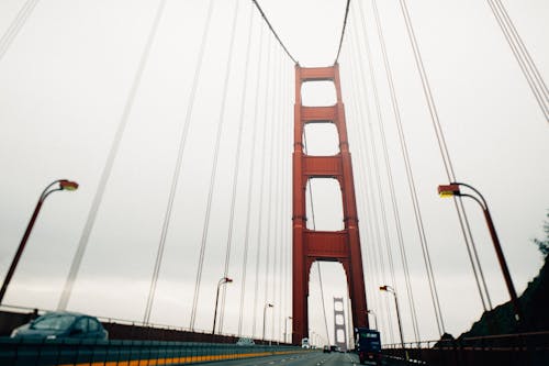 Long suspension bridge with moving cars on cloudy day