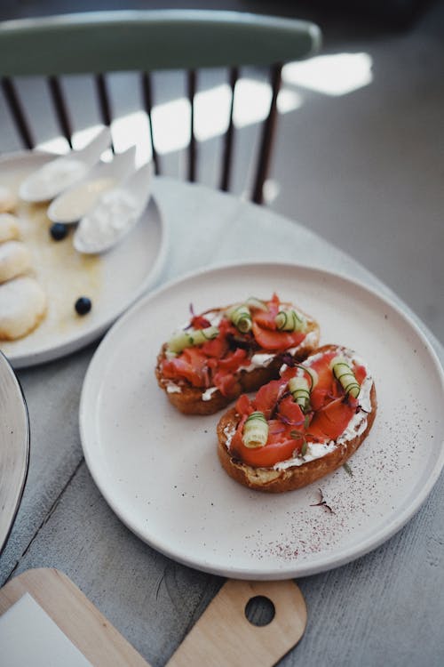 Free From above of tasty bruschetta with tomatoes and mozzarella on white plate served on round wooden table in cozy cafe Stock Photo