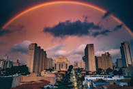 在戏剧性的日落期间，一道生动的彩虹划过令人惊叹的城市天际线