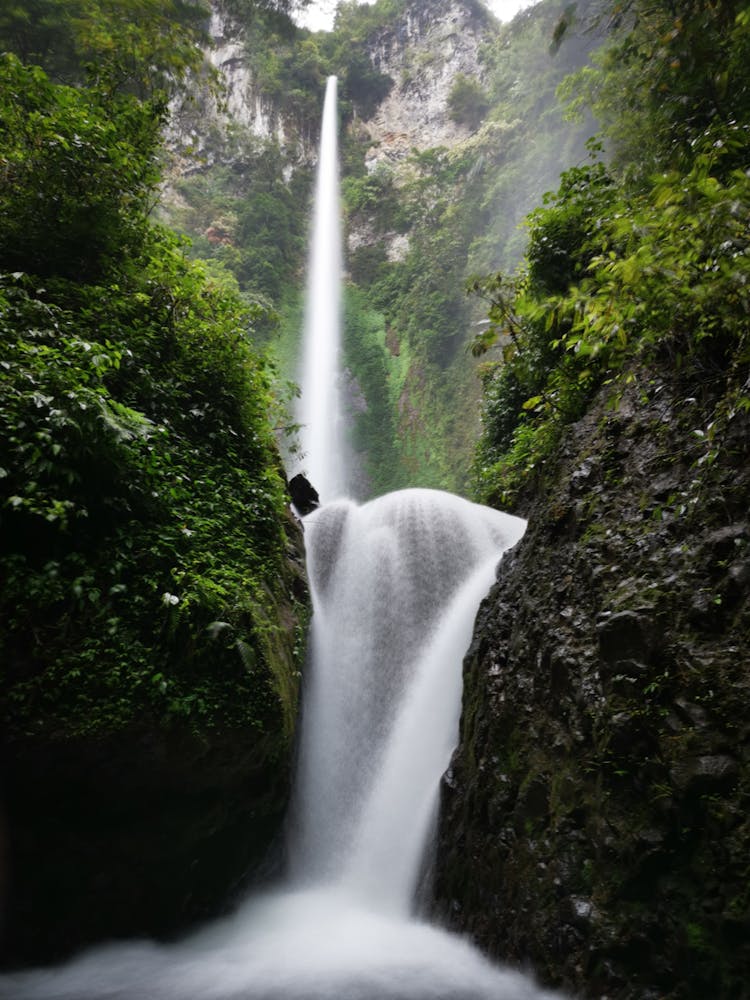 The Pancuran Rayo Waterfall Cascading Between Rocks In Jambi, Indonesia