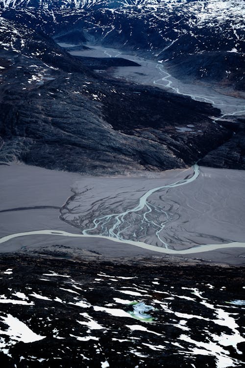 Narrow river flows in snowy mountains in winter