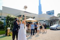 Content bride with groom throwing flower bouquet to guests outdoors