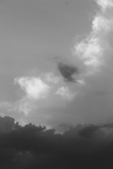 Dramatic black and white clouds, capturing a moody sky in a vertical photo.