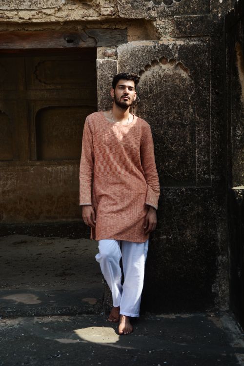 Free Slim unshaven ethnic man in traditional clothes leaning on wall of old building while looking at camera Stock Photo