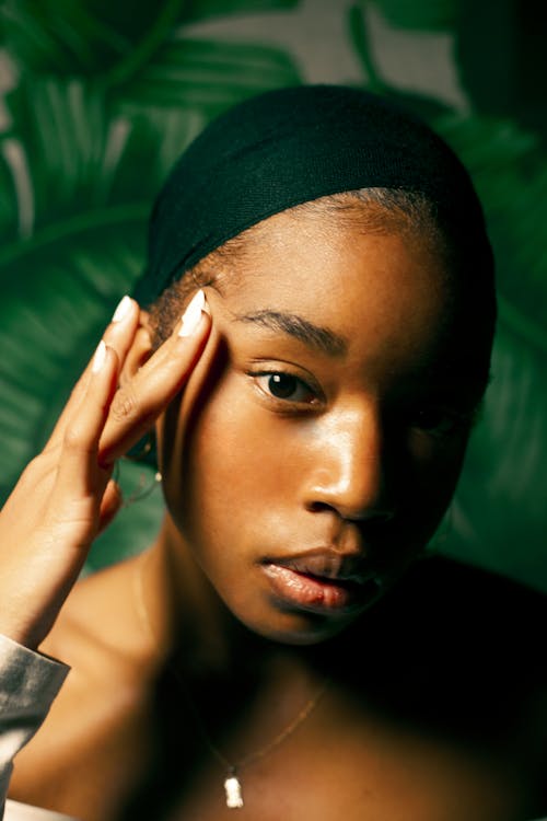 Woman in Black Knit Cap Covering Her Face With Her Hand